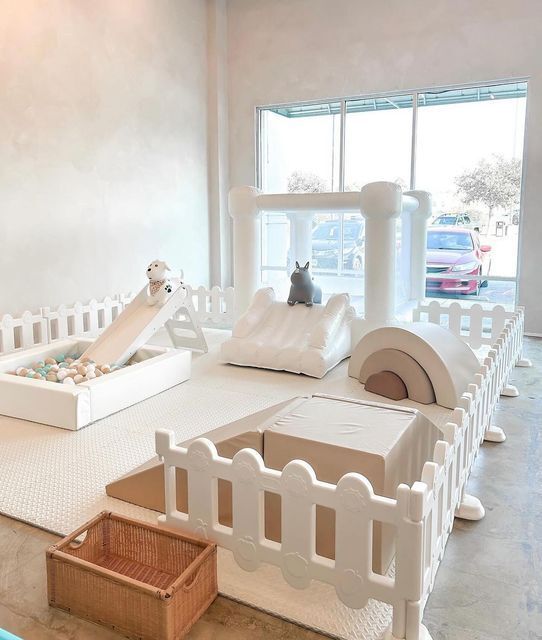 White indoor soft play rental setup with ball pit, slide and white picket fence enclosure