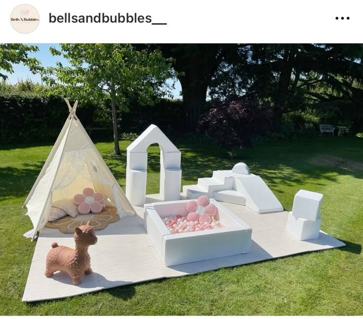 Outdoor DIY soft play area with teepee tent, white foam pieces and pink ball pit on grass